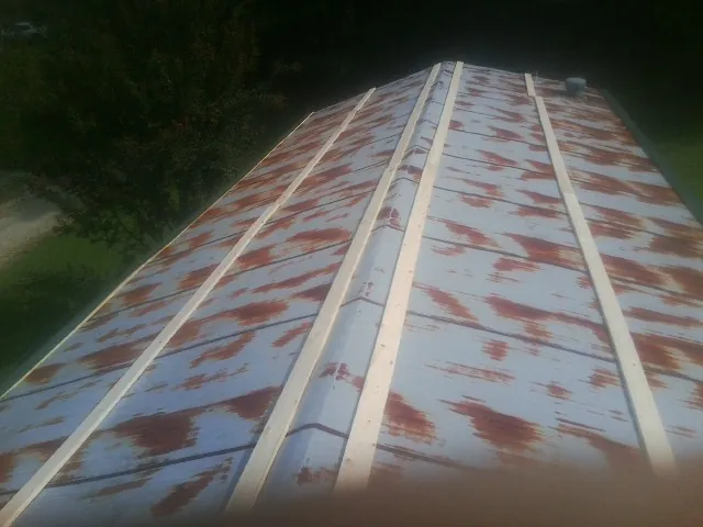 Rusted metal roof panels with new wood purlins before replacement — Storm Damage Roof Repair in East Calais by Roofing Brothers
